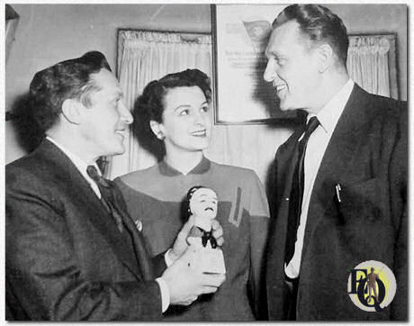 Sidney Kingsley, auteur van "Detective Story", toont Lydia Clarke en Ralph Bellamy, hoofdrolspelers in zijn toneelstuk, de 'Edgar' die hij ontving van de Mystery Writers of America voor zijn authentieke weergave van detectives in zijn succesvolle stuk in het Hudson Theater in New York.