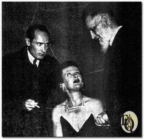 The Plot's against cancer this time - Mystery writer Harold Q. Masur (left) keeps a sharp eye peeled as he listens to a bit of banter between Mrs. Manfred B. Lee, wife of a member of the Ellery Queen team, and pulse-taker Rex Stout, creator of Nero Wolfe. They are shown at the Whodunit Dinner at the Mayflower Hotel to raise funds for cancer research (Oct 16. 1954).