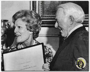 Washington, 18 april 1974 - Een kus en een prijs. Veteraanacteur William Gargan, die zijn strottenhoofd verloor aan kanker, krijgt een kus van First Lady Pat Nixon, samen met de jaarlijkse "courage award" van de American Cancer Society, op donderdag in het Witte Huis. Gargan zei dat hij zich zeer nederig voelde en voegde eraan toe: "Voor het eerst in mijn leven kan ik geen grap bedenken."
