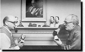 Dannay en Lee in Dannay's woonkamer in Larchmont (1967) , omgeven door hun MWA Awards, Lee (rechts) houdt een MWA's Raven in de handen en Dannay (links) een Edgar . Het portret van Dannay op de mantel is van de hand van Maurice Libby.