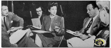 The moment of metamorphosis: Brice (center) becomes Baby Snooks with the help of (from L to R) Daddy Hanley Stafford, script girl Ruth Hahn, Alan Reed (Mr. Weemish) and Arlene Harris (Mommy) (1947)