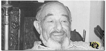 A photograph of an older, bearded Reed sitting on a sofa. He is much slimmer than in previous photos, this plus the beard indicates that the photo was taken sometime late in Reed's life. (c) Alan Reed Collection [digital resource], Pepperdine University Special Collections and University Archives (Used by permission)&nbsp;