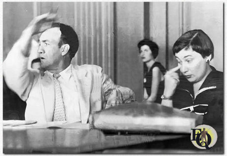 Elliott Sullivan, een 48-jarige acteur die vandaag als getuige verschijnt voor het House Unamerican Activities Committee in de Federale Rechtbank, zwaait met zijn arm tijdens zijn verschijning. Sullivan, die geen beroep deed op het Vijfde Amendement, betwistte het recht en de macht van de commissie om hem te ondervragen over zijn politieke associaties. Hij zei dat het onderzoek heeft geholpen bij het op een zwarte lijst zetten van acteurs om politieke redenen. Bij hem is zijn advocaat, Bella Abzug. (AP Wirephoto 16 augustus 1955)